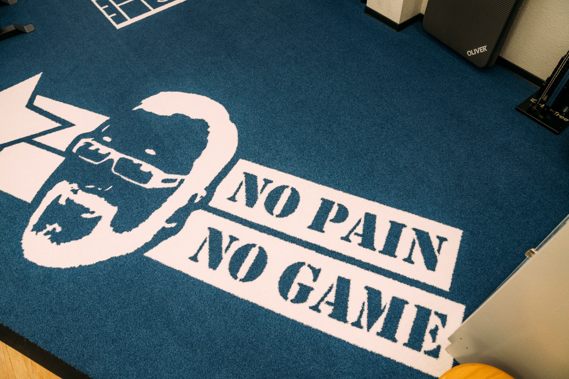 No Pain No Game Logo-Teppich im Trainingsraum